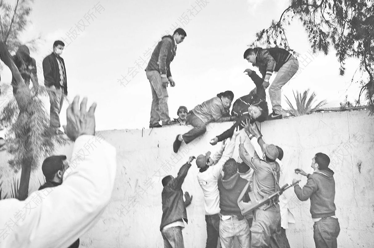 2011年，本加尔丹附近的突尼斯与利比亚边境，负伤的利比亚难民被送过界墙
